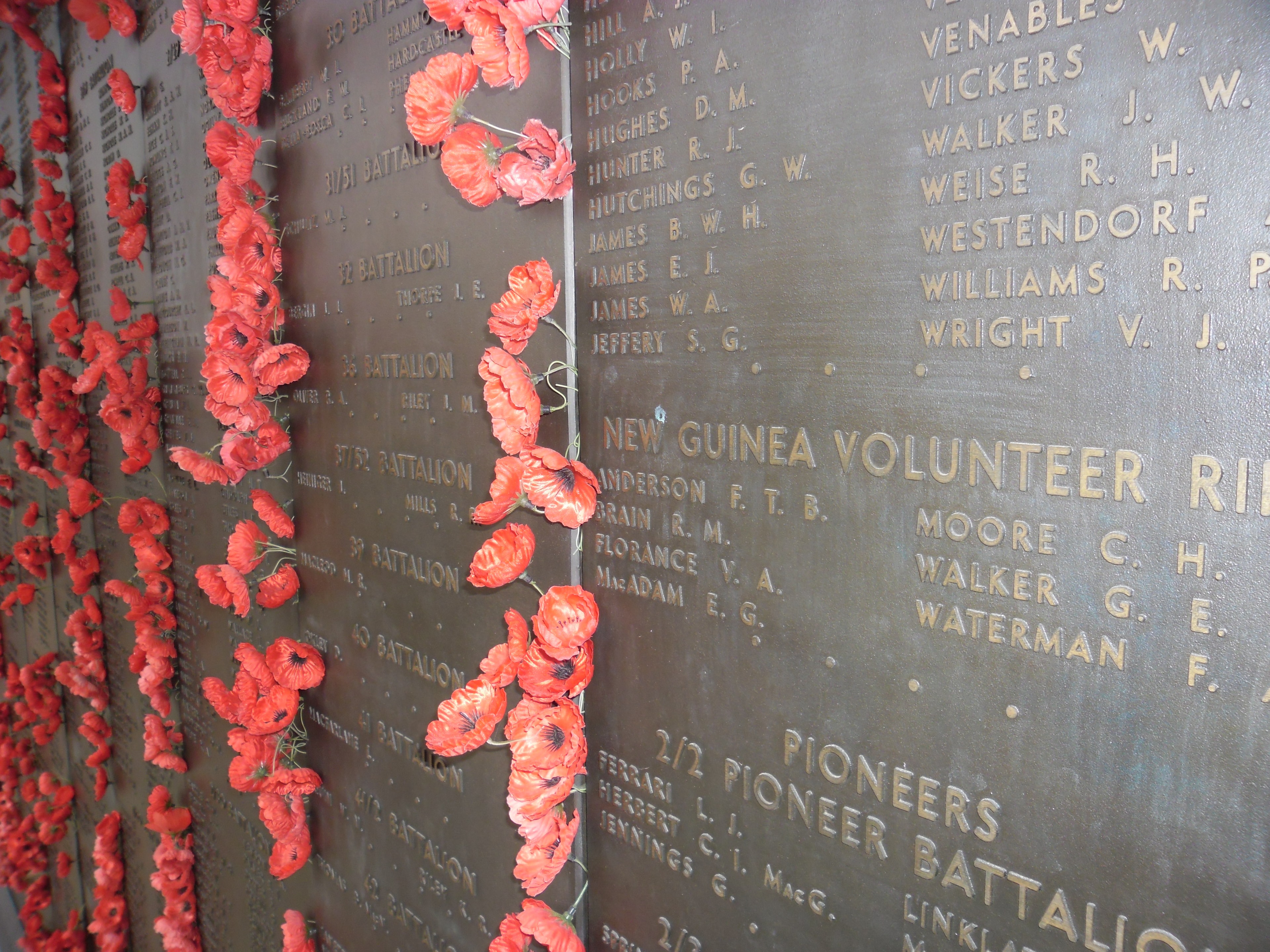 Poppy-adorned war memorial wall